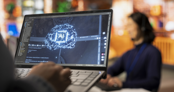 Call center worker using AI tech on laptop to reply to customers, closeup